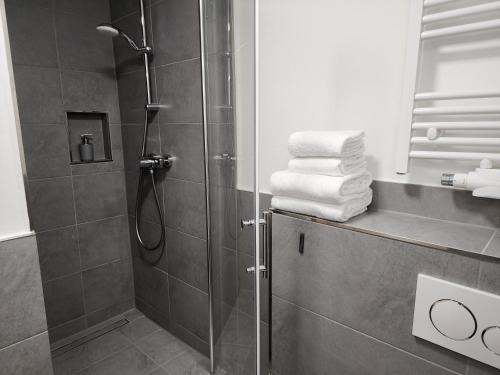 a bathroom with a shower and some towels at Davin City Aparments - Self-Check-In in Hamburg