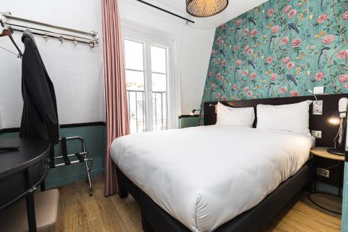 1 dormitorio con cama y pared de flores en Vintage Paris Gare du Nord by Hiphophostels en París