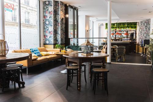 パリにあるヴィンテージ パリ ガール デュ ノール バイ ヒップホップホステルズのテーブルと椅子、ソファ付きのレストラン