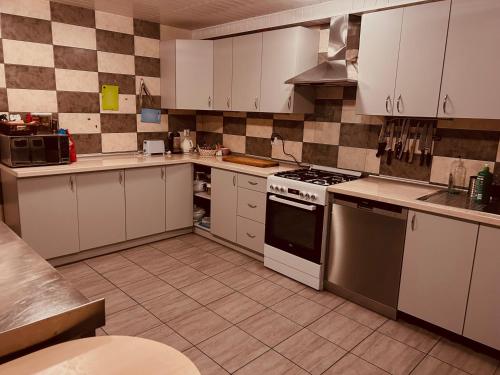 a kitchen with white cabinets and a stove top oven at Domek w Lesie in Karłów