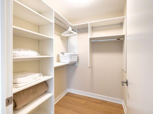 a walk in closet with white shelves and a door at Spacious Apt Downtown with Gym in Stamford