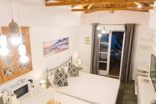 a bedroom with a white bed in a room at in Hydra in Hydra