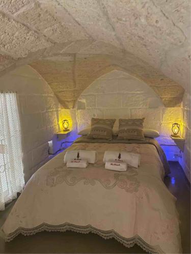 een slaapkamer met een groot bed met blauwe verlichting bij La Ramasola in Fasano