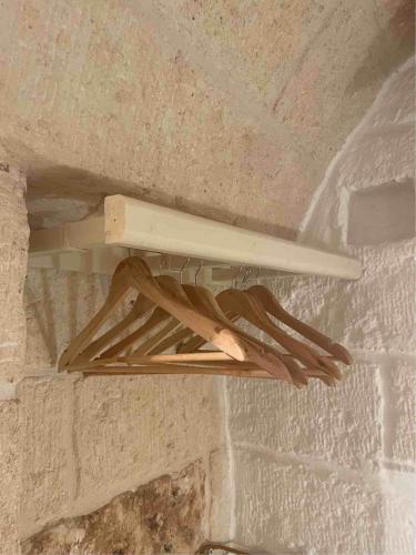 a wooden rack hanging from a brick wall at La Ramasola in Fasano