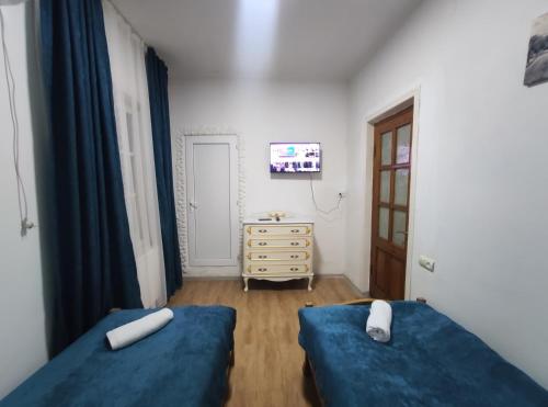 a bedroom with two blue beds and a dresser at Ortachala Summer House in Tbilisi City