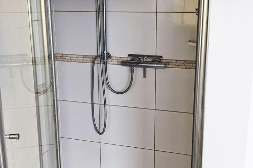 a shower with a hose in a bathroom at Moderne Einliegerwohnung am Wald in Langenfeld