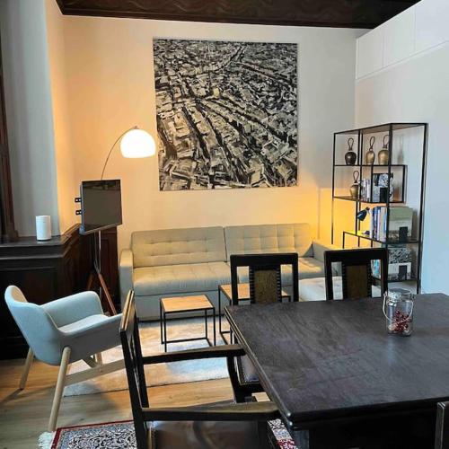 sala de estar con sofá, mesa y sillas en Jugendstiljuwel in Bad Gastein en Bad Gastein