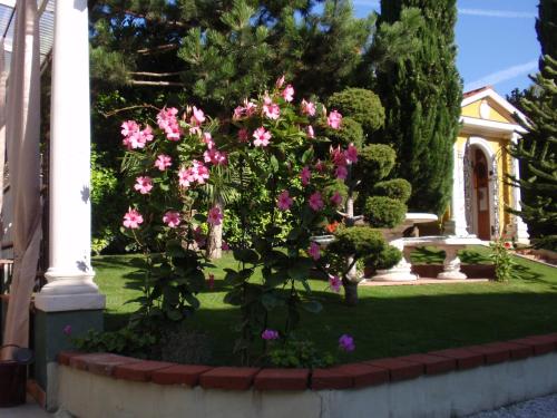 a garden with pink flowers in front of a house at Villa-Angelina in Langenzersdorf