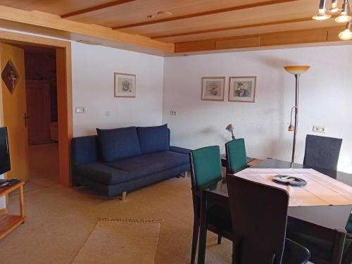 un soggiorno con tavolo e divano blu di Appartement Isolde a Dornbirn