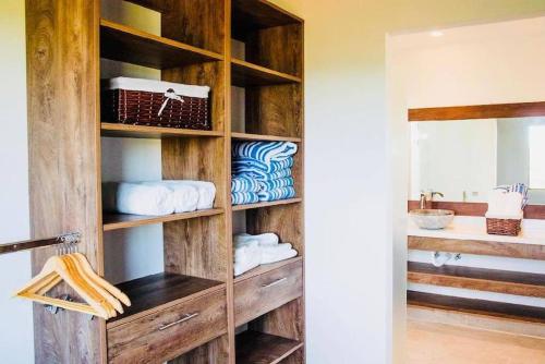 La salle de bains est pourvue d'une étagère en bois et de serviettes. dans l'établissement Elegant Oceanview Penthouse - Steps from Jaco Beach & Nightlife, à Jacó