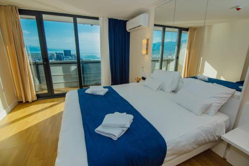um quarto com uma cama grande e toalhas em Panorama Sea View Orbi City em Batumi