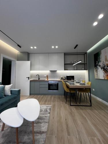 een keuken en woonkamer met een tafel en stoelen bij Luxurious seaside apartment 1 in Durrës