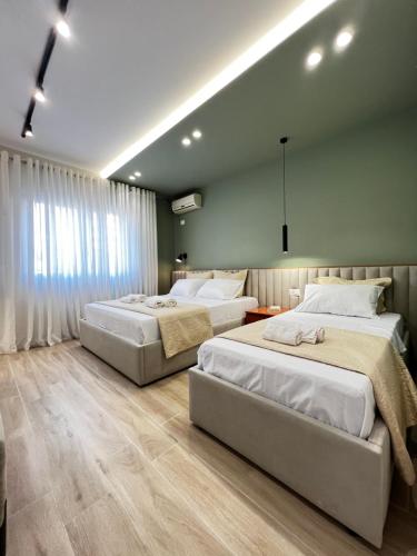 two beds in a large room with green walls at BRAND NEW Luxurious seaside apartment 1 in Durrës