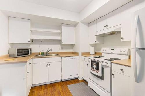 a kitchen with white cabinets and white appliances at 2 Bedroom Private Guest Suite on a hill in Abbotsford