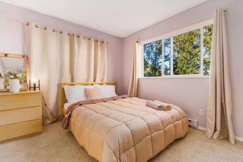 a bedroom with a bed and a large window at 2 Bedroom Private Guest Suite on a hill in Abbotsford