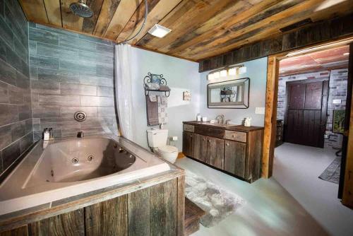 a bathroom with a tub and a toilet and a sink at Fairytale: Hot Tub & Trout Stream & Petting Zoo? in Sugar Grove