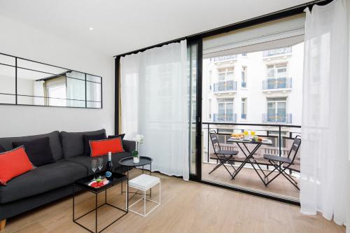 un salon avec un canapé et une grande fenêtre dans l'établissement My Ty Croisette Martinez YourHostHelper, à Cannes