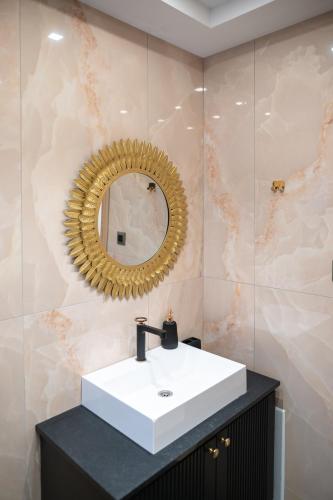 a bathroom with a white sink and a mirror at ELEGANCE SUITES in Plataria