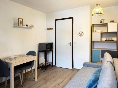 - un salon avec un canapé, une table et une porte dans l'établissement Résidence Les Gradins - Grand studio pour 4 personnes MAE-0714, aux Orres