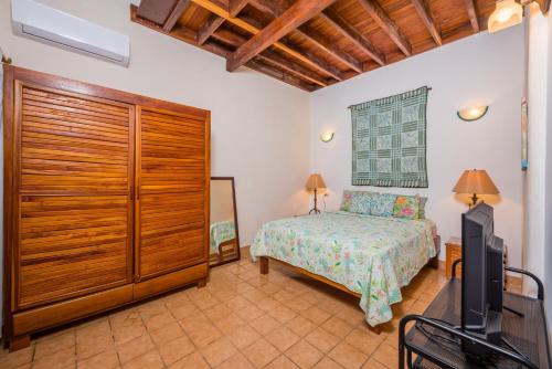 1 dormitorio con 1 cama y TV. en Casa Luna, en Tamarindo