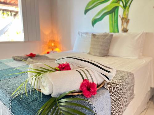 um quarto com uma cama com flores vermelhas em Pousada Nascente do Sol na Ilha de Boipeba