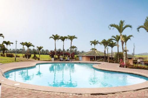 duży basen z palmami w tle w obiekcie Palmar Del Sol Hotel w mieście Quevedo