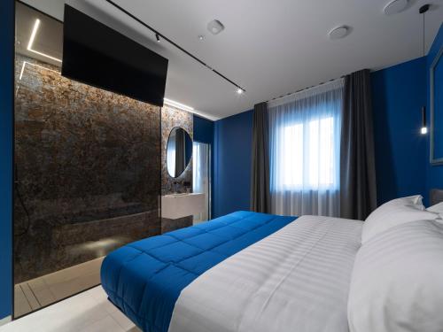 a bedroom with blue walls and a large bed at THE CAVE Suites SPA in Vieste