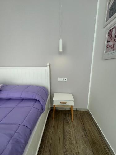 een slaapkamer met een paars bed en een bijzettafel bij Molo '93 - RoomsAndSea in Belvedere Marittimo