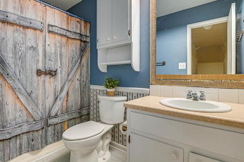 baño con puerta de madera, aseo y lavamanos en Bohemian Beach Retreat - 2 Blocks to Ocean! en Myrtle Beach