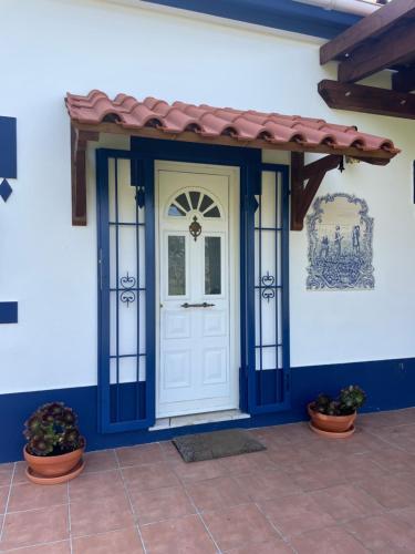 a white door with a red roof on a house at Monte Velho - Country House in Canha
