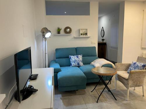 sala de estar con sofá azul y mesa en Corazón de Granada, en Granada
