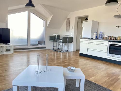 sala de estar con mesa blanca y cocina en Living in a penthouse in Frankfurt, with balcony for smokers, en Frankfurt