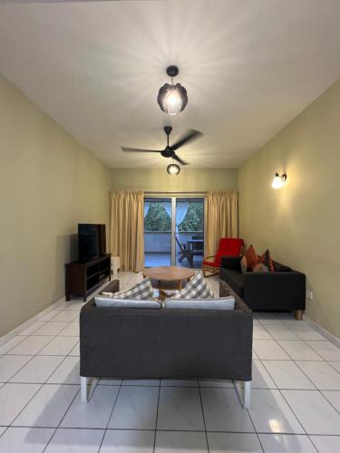a living room with two couches and a ceiling fan at The Oxford Suite in Bentong