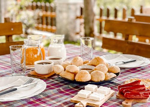 un tavolo con un piatto di pane, formaggio e latte di Vila Alpini a Razëm