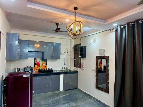 a kitchen with blue cabinets and a mirror at Cozy 2bhk near Manipal Hospital Dwarka in New Delhi