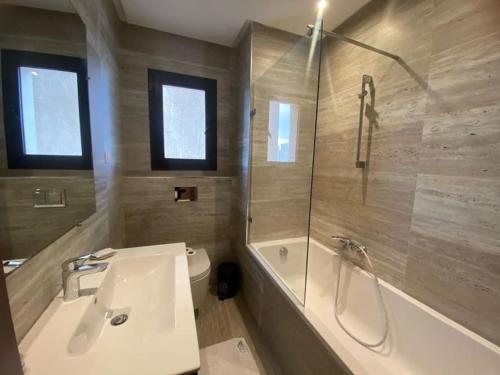 a bathroom with a tub and a sink and a shower at Carthage Garden Appartement in Sidi Daoud