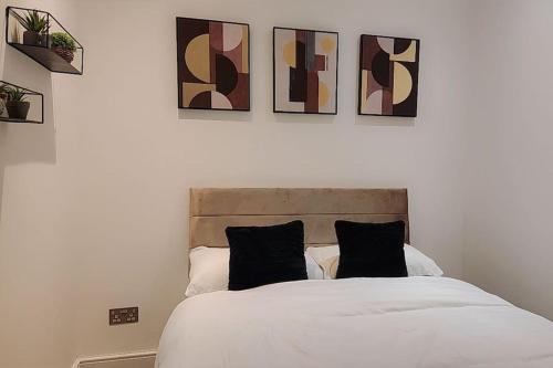 a bedroom with a white bed with black pillows at 3 Bedroom, 3 Bathroom, Modern Apartment, Leicester in Leicester