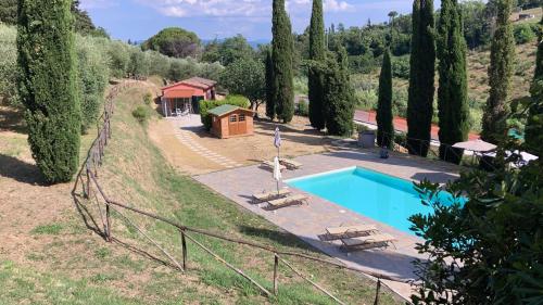 a house with a swimming pool in a forest at Garden Relais Le Fontanelle in Montescudaio