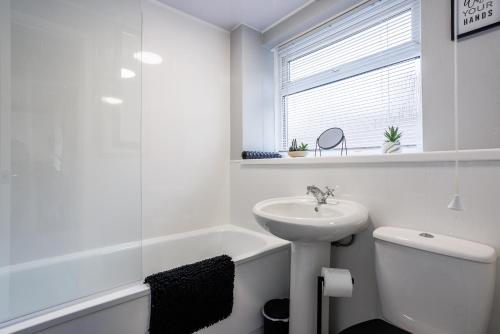 a white bathroom with a sink and a toilet at Lily Rose in Bedlington