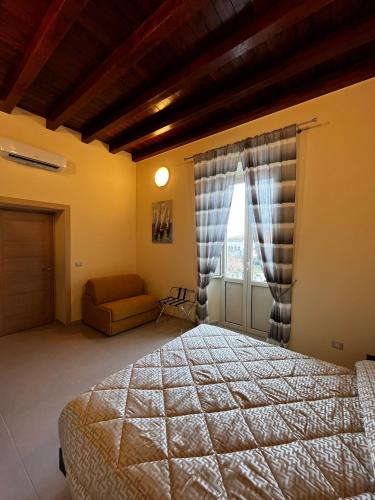 a bedroom with a bed and a window with a couch at IN CENTRO Rooms and Apartments in Isola del Liri