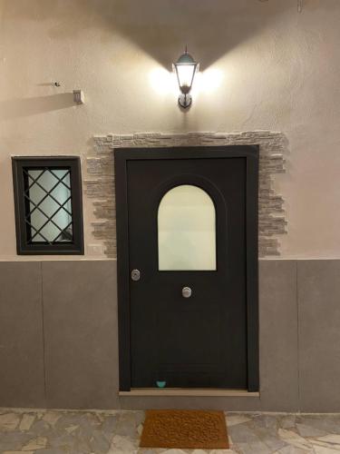 a black door in a room with a window at Room 248 Capodimonte in Naples
