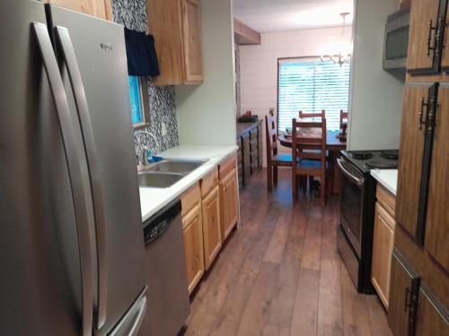 a kitchen with a stainless steel refrigerator and wooden cabinets at Mountain Hideaway in Crouch