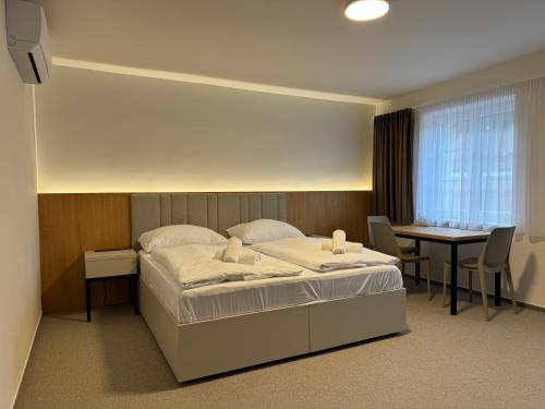 ein Hotelzimmer mit einem Bett und einem Tisch in der Unterkunft Eden Pálava, Penzion & Restaurant in Klentnice