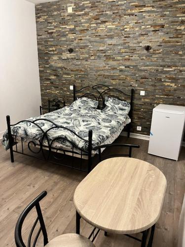 ein Schlafzimmer mit einem Bett, Tischen und einer Ziegelwand in der Unterkunft Appartement Creil Centre-ville in Creil