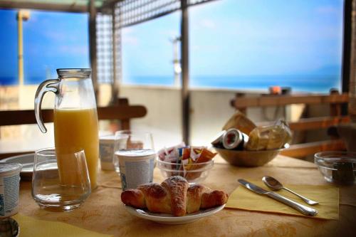 uma mesa com um prato de pão e um jarro de sumo de laranja em B&B Donna Nina em Gioia Tauro