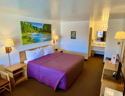 Habitación de hotel con cama grande y baño. en Red Bear Inn en Ennis
