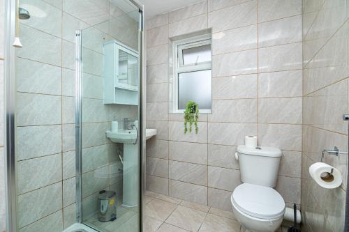 W łazience znajduje się toaleta i przeszklony prysznic. w obiekcie Luxurious 2 bed house - Free Parking w mieście Thamesmead