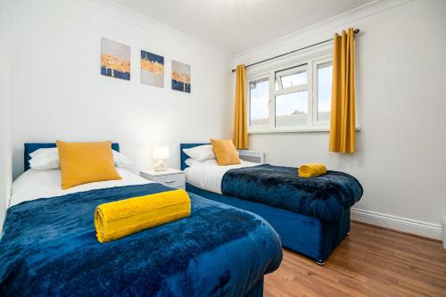 a bedroom with two beds and a window at Luxurious 2 bed house - Free Parking in Thamesmead