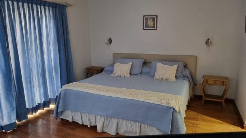 sypialnia z niebieskim łóżkiem i niebieskimi zasłonami w obiekcie La Niña w mieście Salta