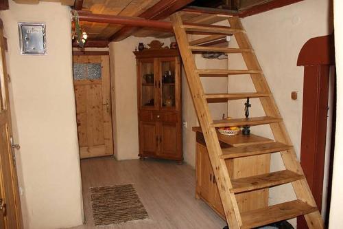 Una habitación con una escalera de madera en una habitación en Roubenka U Myšáka Jizerské hory, en Tanvald